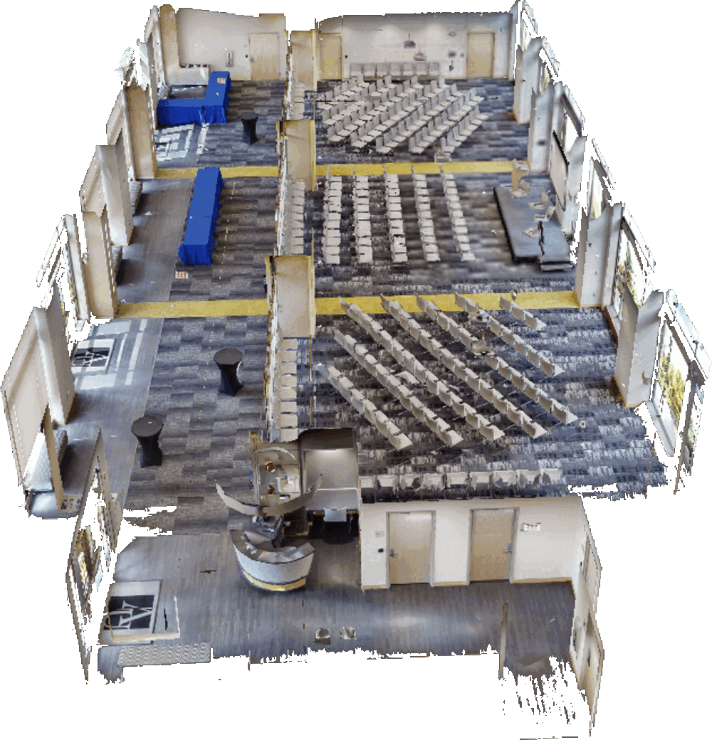 A cutaway three-dimensional model of the East Campus Commons seen from above, showing a large room laid out with rows of chairs, draped tables along one side, and a lobby with doors at the front.